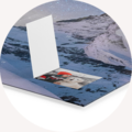 En åben CEWE fotoalbum på blå baggrund, med et billede visibelt.